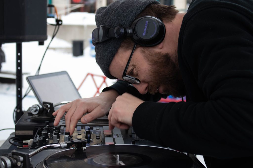 Tyler DJing, looking closely at his turntables.