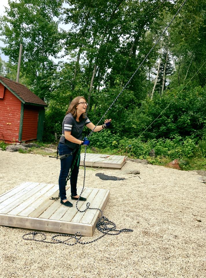 Kaitlyn belaying at an outside rock climbing wall.