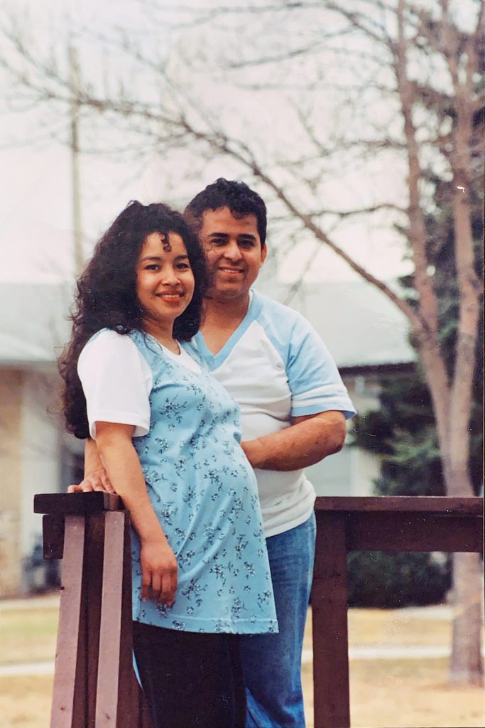 A portrait of Oscar and Karen outside. Karen is notably pregnant.