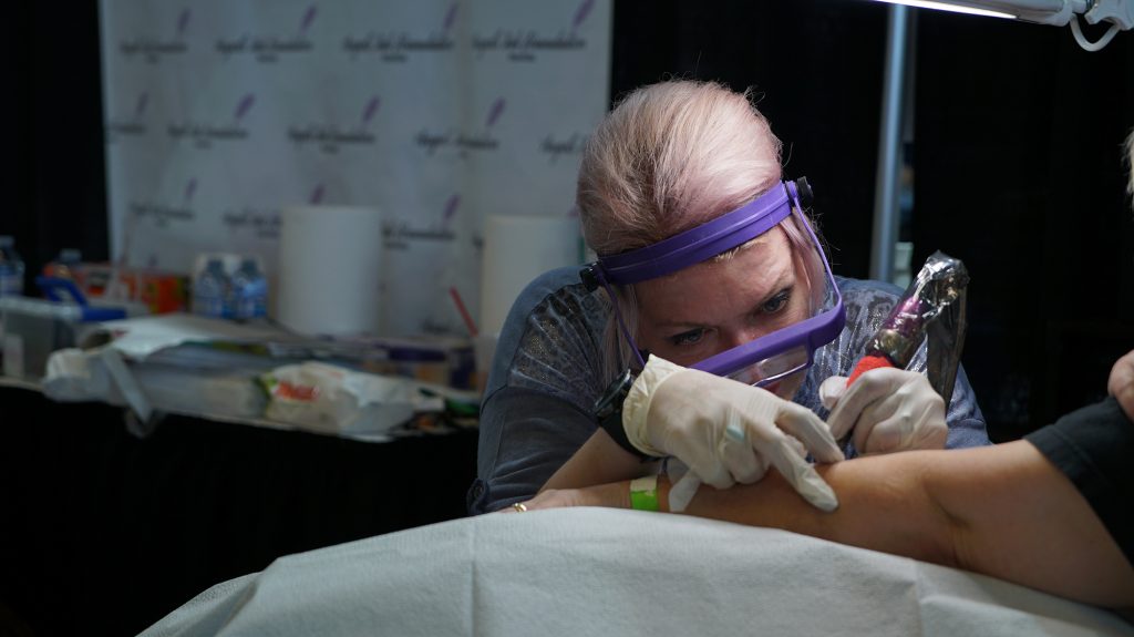 Keri Hamilton tattoos on a client at the Winnipeg Tattoo Show.
