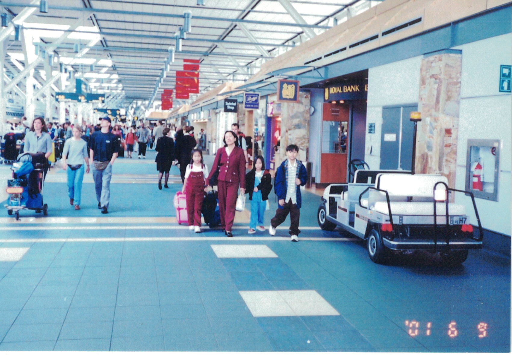 Amidst a crowded airport, Alyssa's mother, brother, sister and her pull their luggage behind them.