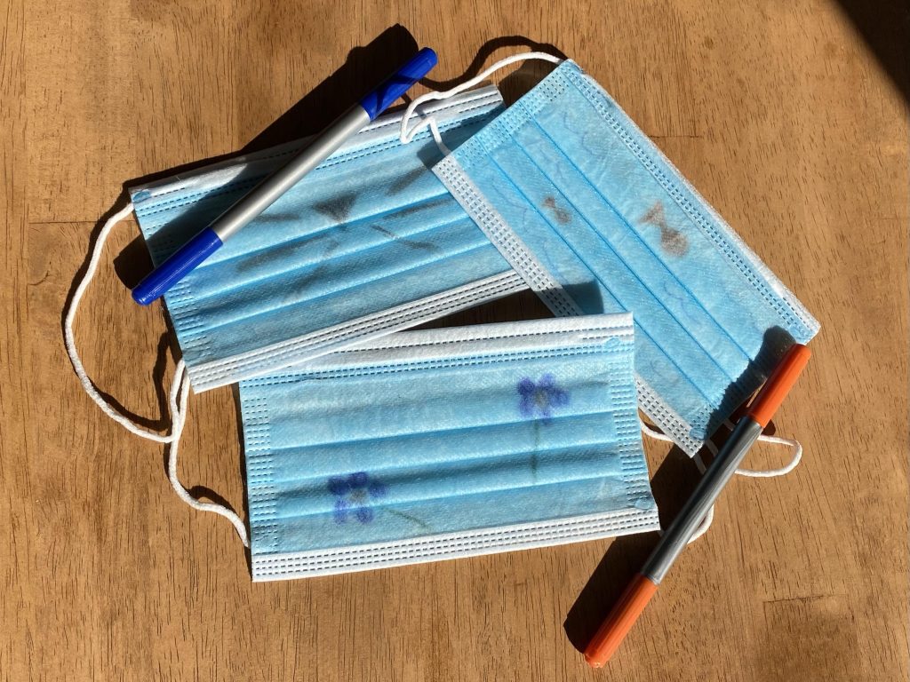3 medical masks decorated with markers.