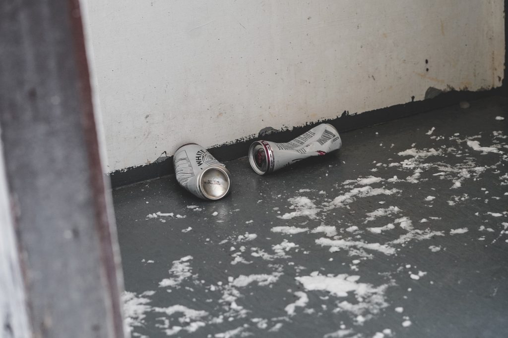 Two White Claw cans sit on the floor of the outhouse at McGillivry Falls Self-guiding Trail