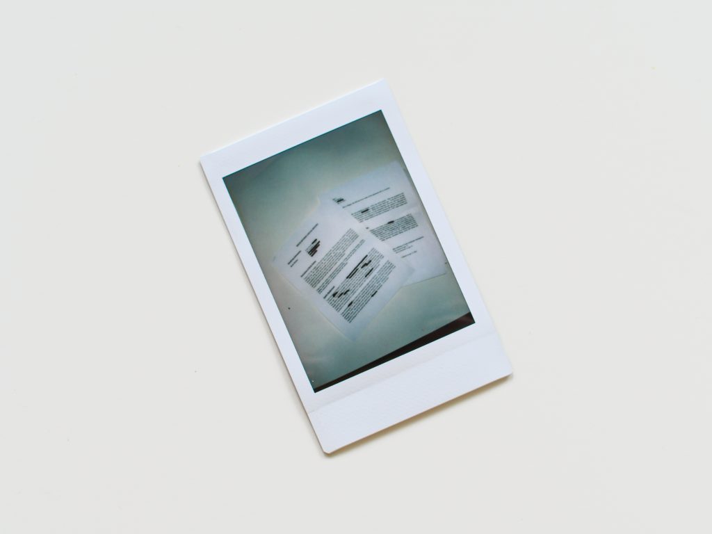 A polaroid image of blacked out adoption paperwork.