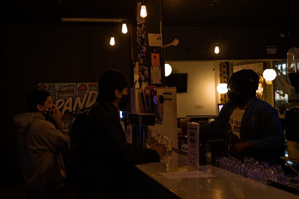 Jeremy Haywood-Smith serves up a pint to a patron behind The GoodWill bar