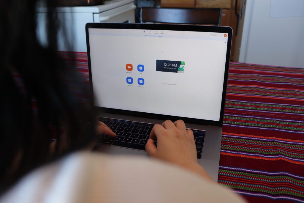 A woman opens up Zoom video chat on her laptop.
