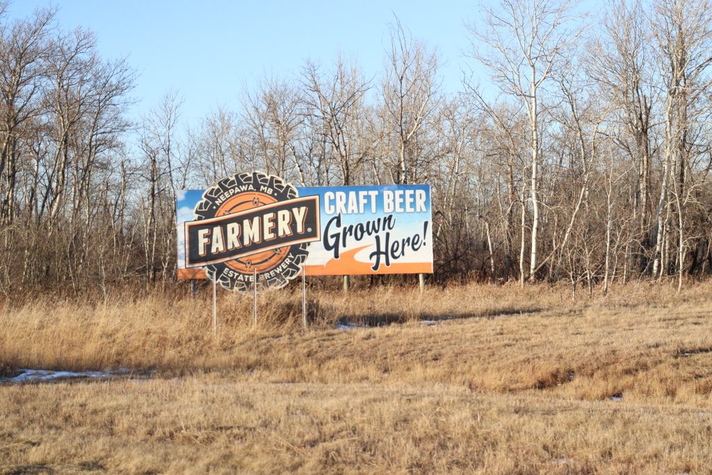 A roadside billboard for Farmery Brewing.