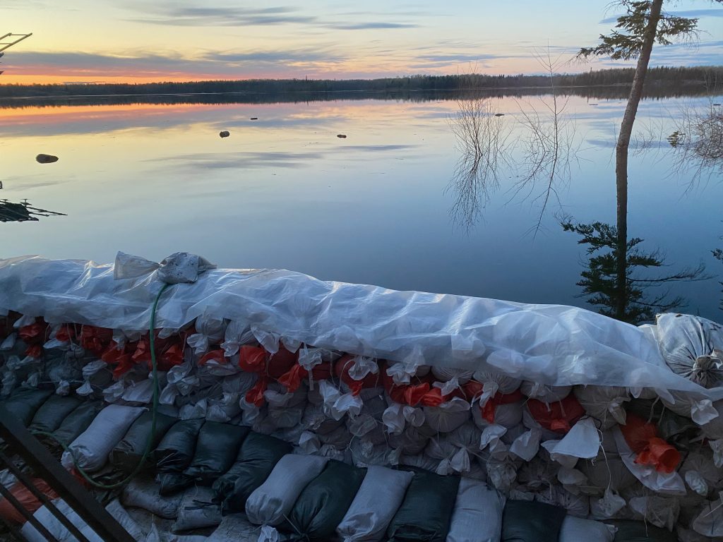 A dike with white and orange sandbags facing the water.