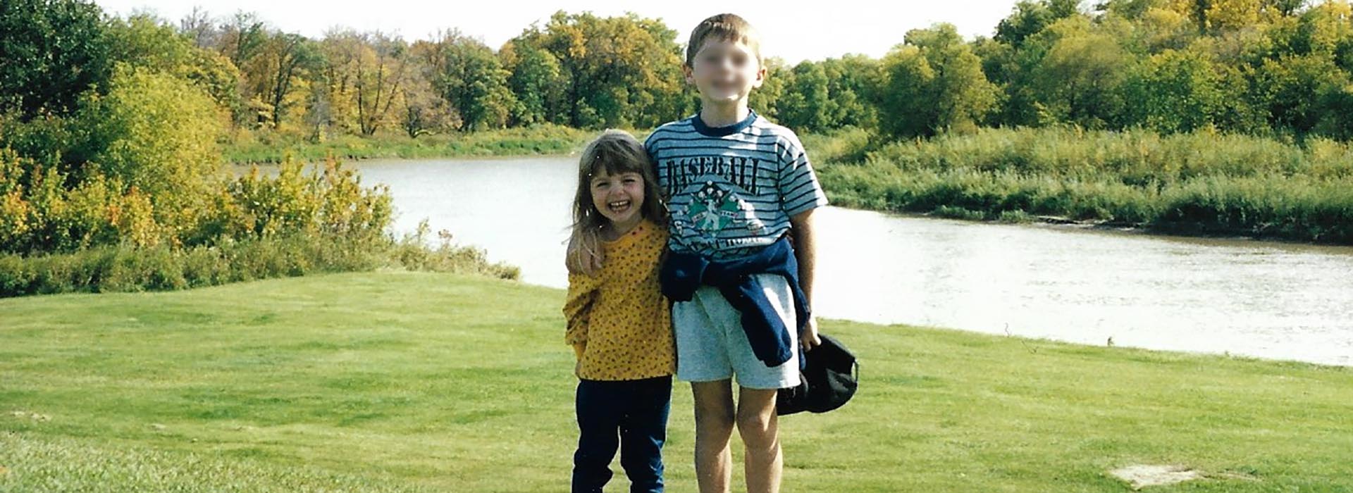 Bryn and Benjamin stand in a field as kids
