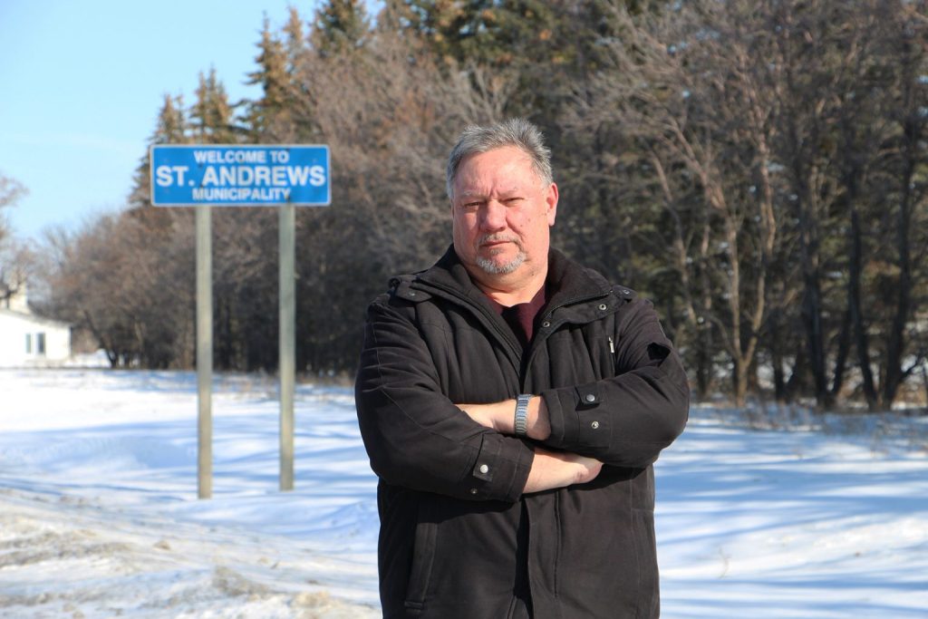 Tom Watson stands in front of a "Welcome to St. Andrews Municipality" sign.