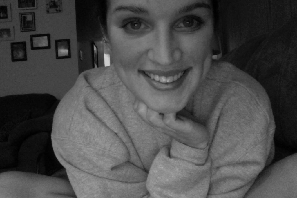 Sam Toews smiles at the camera on her laptop.