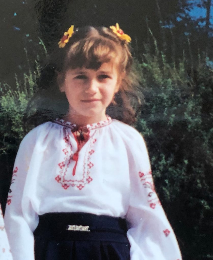 A photo of Lilya at eight years old dressed in a traditional Ukrainian blouse after a recital.