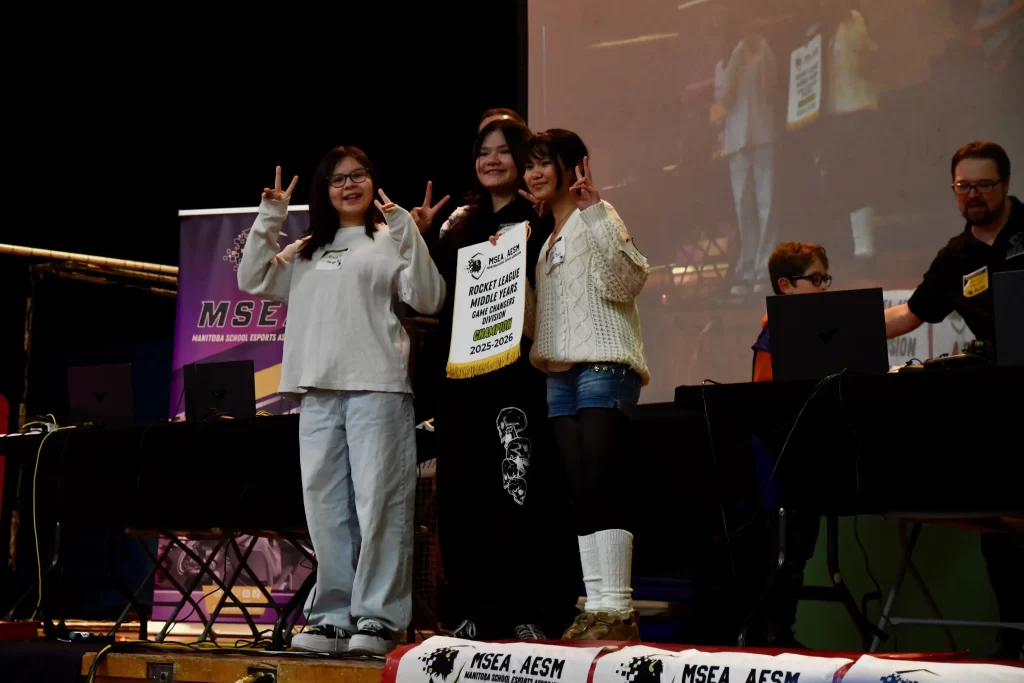 Students holding a championship banner on stage.