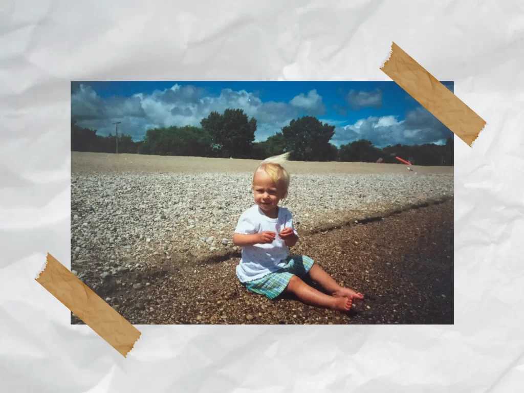 Scrapbook style page, picture from childhood on the beach in Gimli. Tape holding up the sides of the picture. 