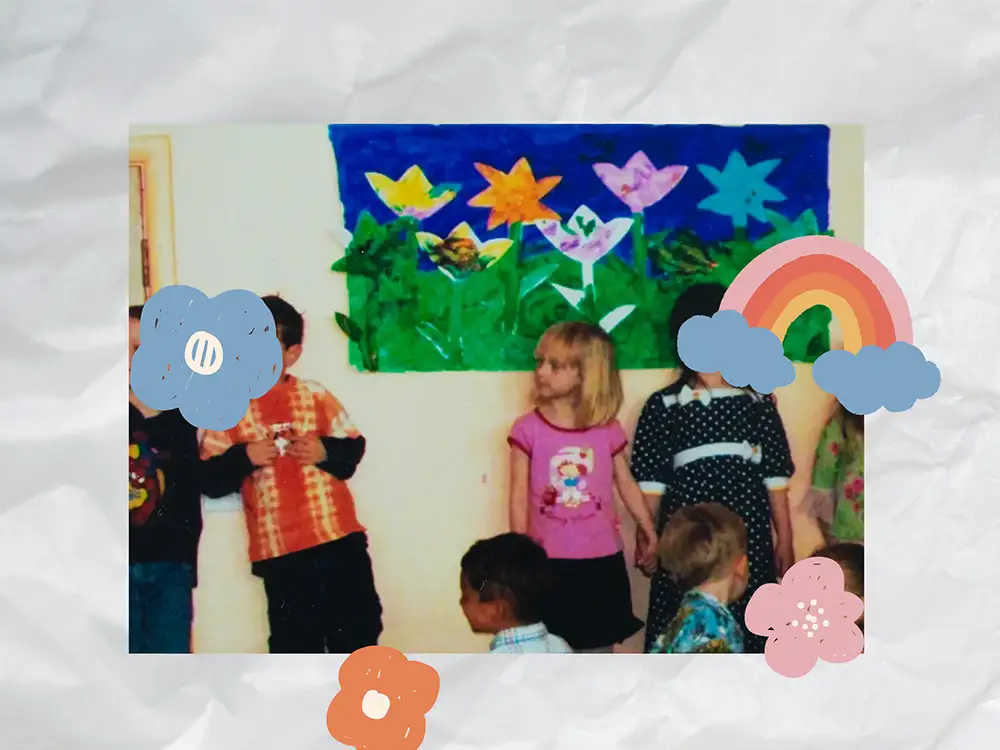 Scrapbook style page, picture from preschool of me holding hands with my friend. Stickers cover the page. 