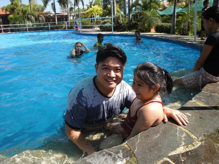 Father and daughter at a swimming pool