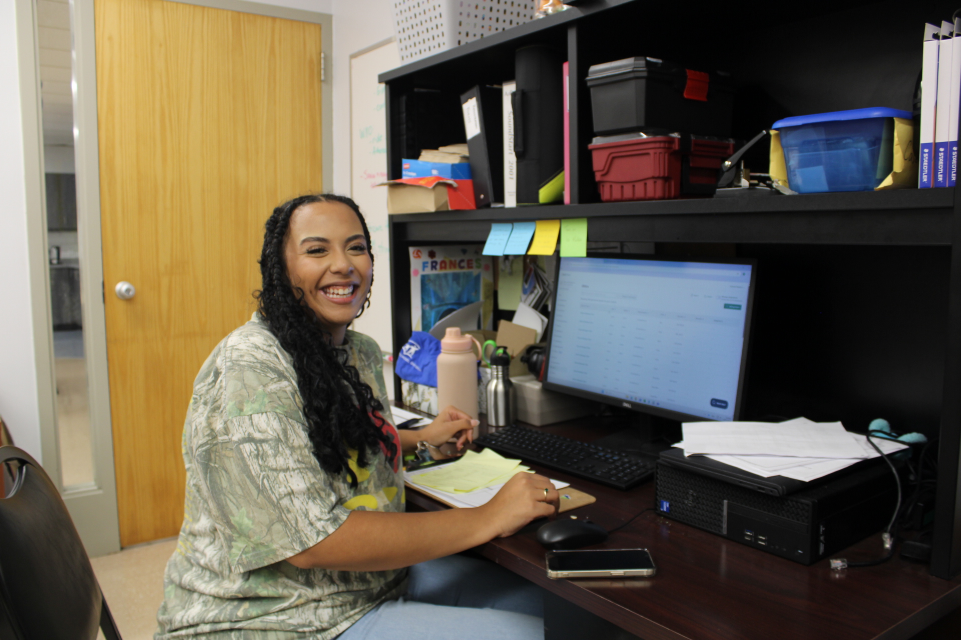 Woman sitting in an office smiling at camera.