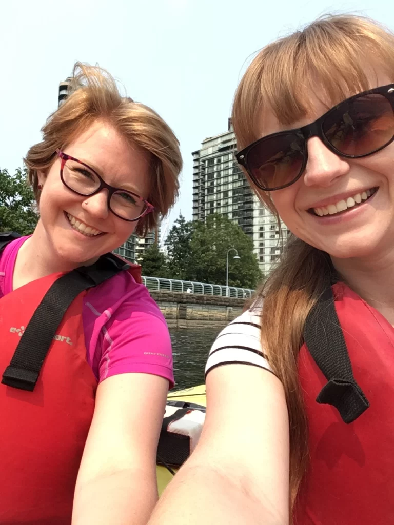 Two women with strawberry blonde hair blonde hair take a selfie while kayaking in Vancouver.