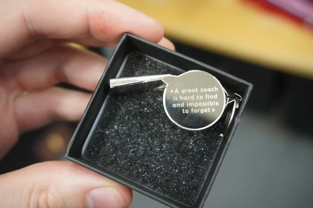 An engraved whistle "A great coach is hard to find and impossible to forget".