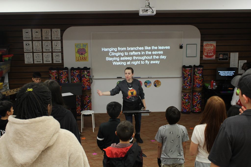 Woman conducting a class of choir students